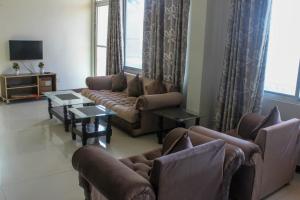 sala de estar con sofás, mesas y TV en Green Valley Bhurban Apartments, en Bhurban
