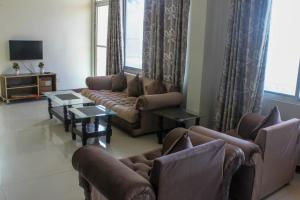 un salon avec des canapés, des tables et une télévision dans l'établissement Green Valley Bhurban Apartments, à Bhurban