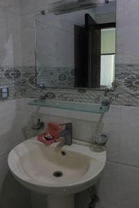 une salle de bain avec un lavabo blanc et un miroir dans l'établissement Green Valley Bhurban Apartments, à Bhurban 13 autres photos