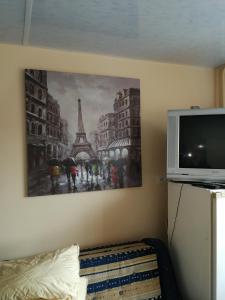 a bedroom with a painting of the eiffel tower at 1 kambario butas in Panevėžys