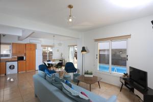 uma sala de estar com um sofá azul e uma mesa em SeaBreeze Villas by TrulyCyprus em Agia Napa
