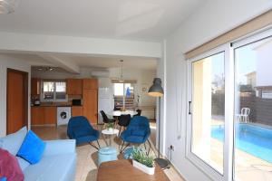 a living room with a blue couch and a table at SeaBreeze Villas by TrulyCyprus in Ayia Napa