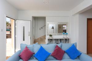 uma sala de estar com um sofá azul com almofadas coloridas em SeaBreeze Villas by TrulyCyprus em Agia Napa