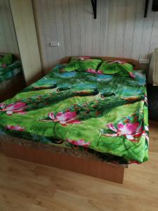 - un lit avec une couette verte et des fleurs dans l'établissement Flat, 1 room, study, à Panevėžys