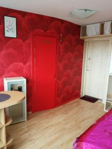 une porte rouge dans une pièce avec un mur rouge dans l'établissement Flat, 1 room, study, à Panevėžys