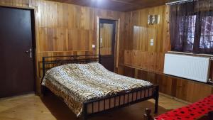 una camera da letto con un letto in una stanza con pareti in legno di Binuli House a Kobuleti