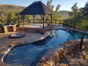 an infinity pool with a gazebo and a swimming pool at Bona Kgole Private Game Lodge, Mabalingwe in Warmbaths