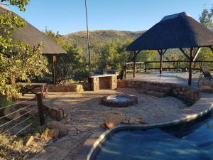 a backyard with a swimming pool and an umbrella at Bona Kgole Private Game Lodge, Mabalingwe in Warmbaths