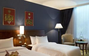 a hotel room with two beds and a lamp at Novotel Bangkok Suvarnabhumi Airport - SHA Extra Plus Certified in Lat Krabang
