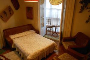um quarto com uma cama, uma cadeira e uma janela em Comfortable House Center (2) em Burgos