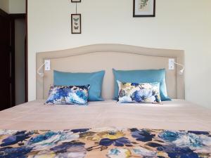 a bedroom with a large bed with blue pillows at Vivenda do Paúl in Geres