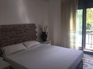 - une chambre avec un lit blanc et un mur en briques dans l'établissement Domus Valencia Apartamentos centro frente a Torres de Serrano, à Valence