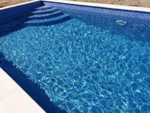 - une piscine bleue avec de l'eau bleue dans l'établissement Villa Fabiola, à Fogás de Tordera