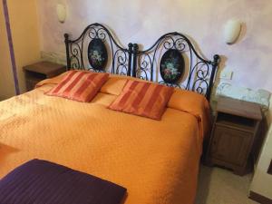 Una cama naranja con dos almohadas encima. en Affittacamere Belfiore, en Florencia