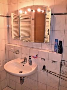 ein Badezimmer mit Waschbecken und Spiegel in der Unterkunft Eine schöne 3-Zimmer-Wohnung mit Ostsee-Zugang! in Juliusruh + 23 Fotos