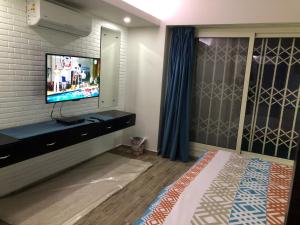 ein Schlafzimmer mit einem TV an einer Backsteinwand in der Unterkunft Sporting Suite Studio in Alexandria