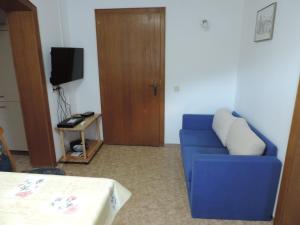 a living room with a blue couch and a television at Ferienwohnung Rudigier Elke in Silbertal