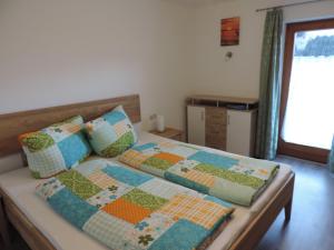 a bed with two pillows and a quilt on it at Ferienwohnung Rudigier Elke in Silbertal