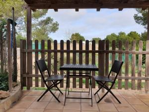 una mesa y sillas en un patio con una valla en Tranquilidad y naturaleza a 800m Playa Migjorn en Playa de Migjorn