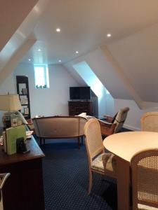 een woonkamer met een bank en een tafel en stoelen bij Villa des Fleurs d'Ajoncs in Concarneau