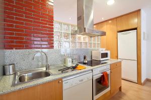 a kitchen with a sink and a brick wall at Calle Sant Miquel 18, 2º 1ª in Tossa de Mar