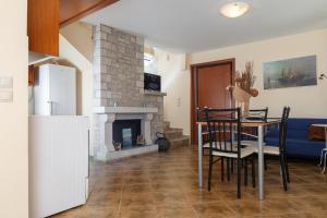 a dining room with a table and a fireplace at Glyfada Villas in Paralio Astros