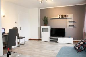 a living room with a television and a desk at Ferienwohnung Jasmin in Hannover