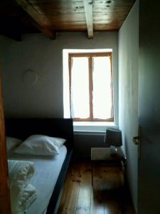 a bedroom with a bed and a window at La Source des Diounes in Besse
