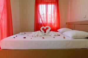 a bed with a heart decoration on top of it at Glyfada Villas III in Paralio Astros
