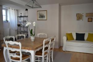 a dining room with a table and chairs and a couch at La Maison Des Buis in Falaise