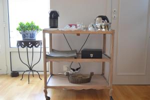a wooden shelf with a basket on it in a room at La Maison Des Buis in Falaise