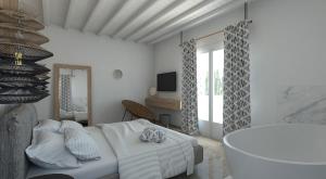 a white bedroom with a bed and a tub at Apiro Mykonos in Mikonos
