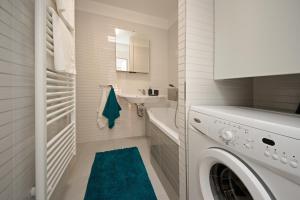 biała łazienka z pralką i umywalką w obiekcie apartmán Marica w mieście Luhačovice