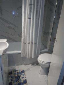 Baño blanco con aseo y lavamanos en Apartamento Luz en Buenos Aires