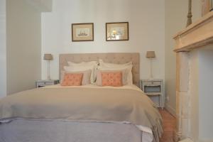 a bedroom with a large bed with two night stands at La Maison Des Buis in Falaise