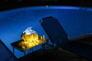 a swimming pool with a table and a chair in front at Glyfada Villas || in Paralion astros