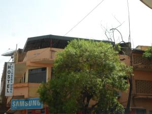 um edifício com uma árvore em frente em Climbers Home em Moshi