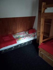 1 dormitorio con 1 cama con cabecero de madera en Penzion Roudenka, en Jestrabi V Krkonosich