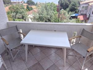 - Balcón con mesa blanca y sillas en Casa di Theo en PalaiónTsiflíkion