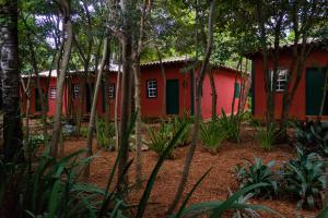 um edifício vermelho e verde na floresta em Pousada Villa Madorna em Santana do Riacho