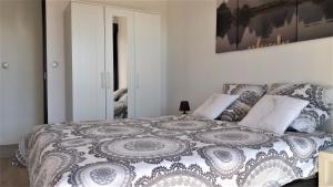 a bedroom with a bed with a comforter and pillows at Rez de jardin - Calme et nature aux portes de Grenoble in Corenc