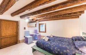 a bedroom with a blue bed and wooden ceilings at Charme Home in Venice