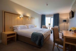 a hotel room with a large bed and a desk at Hotel Minella & Leisure Centre in Clonmel