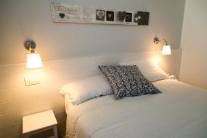a bedroom with a white bed with two lights on it at B&B Bucci 54 in Morciano di Romagna