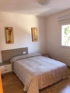 Schlafzimmer mit einem Bett und einem Fenster in der Unterkunft Casa con piscina e impresionantes vistas in Gandía