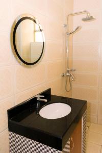 a bathroom with a sink and a mirror at Diamonds Hotel Kampala in Kampala