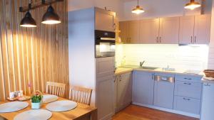 a kitchen with a wooden table with two plates on it at Primo Relax in Starý Smokovec