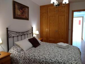 1 dormitorio con 1 cama y armario de madera en Apartamento Paraiso Sol, en Torrox Costa