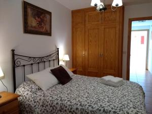 a bedroom with a bed and a wooden cabinet at Apartamento Paraiso Sol in Torrox Costa