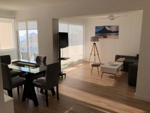 a living room with a dining table and a living room with a television at Nautico Beach & Golf Alicante in Alicante